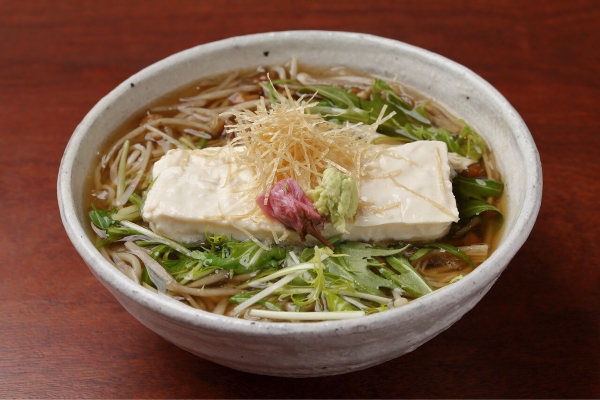 比叡湯葉そば　2200円　　　　　　湯葉をふんだんに使用したお蕎麦を季節限定で用意致しました。水菜やごぼう、なめこ、きざみ湯葉が入ったお蕎麦には、桜の花が添えられており、見た目も鮮やかで春の訪れを感じます。